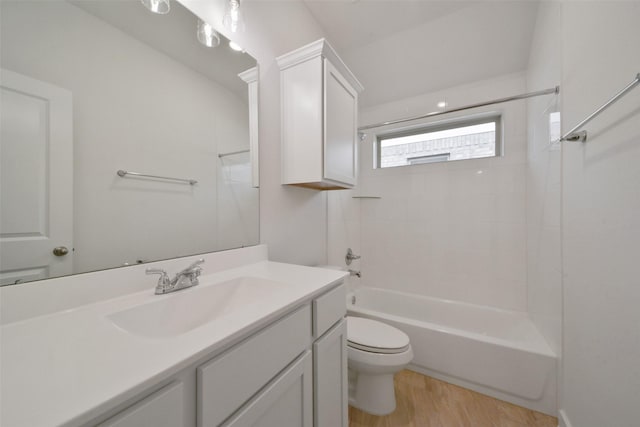 full bathroom featuring tiled shower / bath, vanity, toilet, and hardwood / wood-style floors