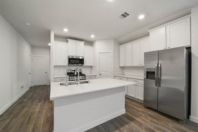 kitchen with white cabinetry, stainless steel appliances, and a center island with sink