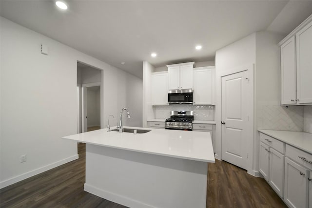 kitchen with stainless steel appliances, sink, an island with sink, and white cabinets