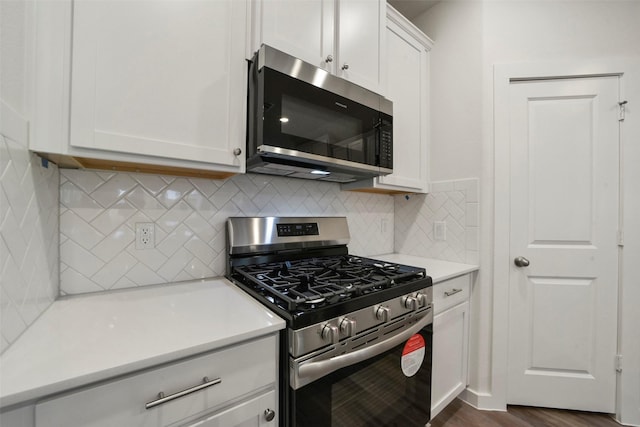 kitchen featuring white cabinetry, decorative backsplash, dark hardwood / wood-style flooring, and stainless steel appliances