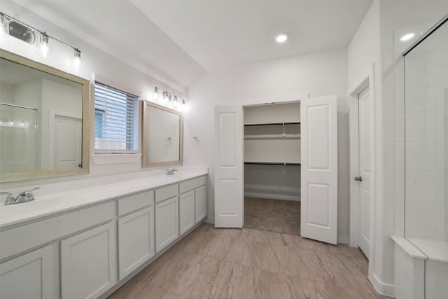 bathroom featuring walk in shower and vanity