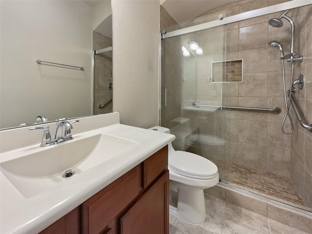 bathroom featuring vanity, toilet, and a shower with shower door