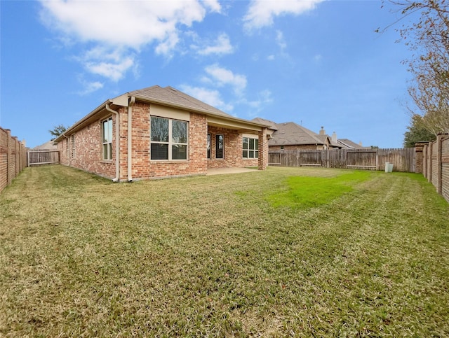 rear view of property featuring a yard and a patio