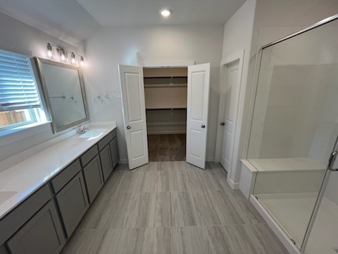 bathroom with vanity, an enclosed shower, and lofted ceiling