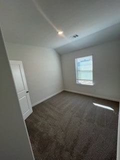 unfurnished room with dark carpet