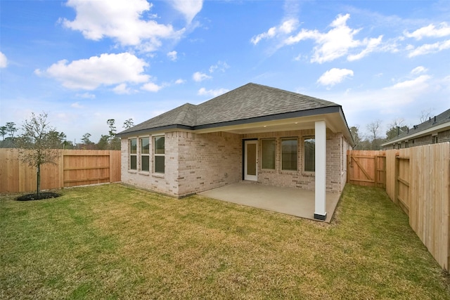 rear view of property featuring a yard and a patio