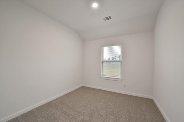 spare room featuring lofted ceiling and carpet