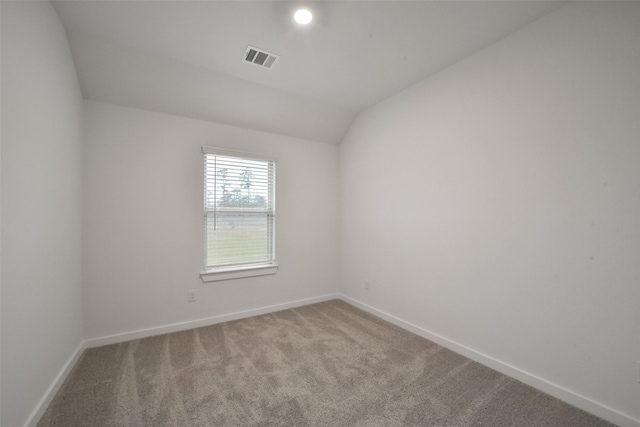 carpeted spare room with lofted ceiling