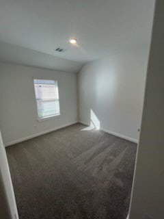 carpeted empty room with lofted ceiling