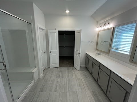 bathroom with vanity, vaulted ceiling, and walk in shower