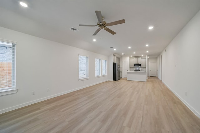 unfurnished living room featuring light hardwood / wood-style flooring and ceiling fan