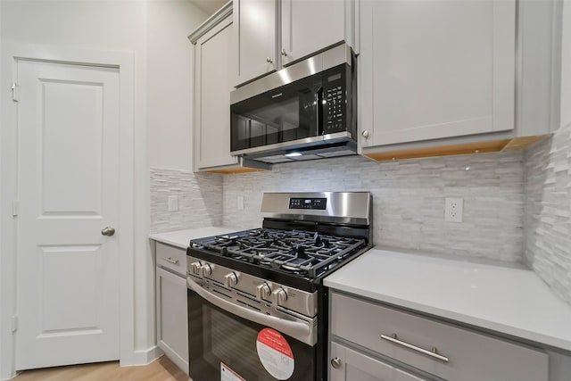 kitchen featuring gray cabinetry, backsplash, and appliances with stainless steel finishes