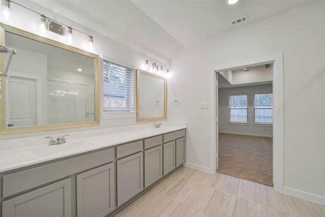 bathroom featuring an enclosed shower, vanity, and lofted ceiling