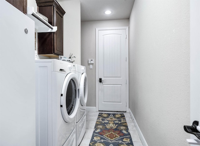 laundry area with light tile patterned flooring, cabinets, and washing machine and clothes dryer