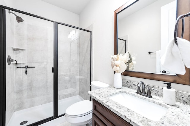 bathroom with vanity, toilet, and a shower with shower door