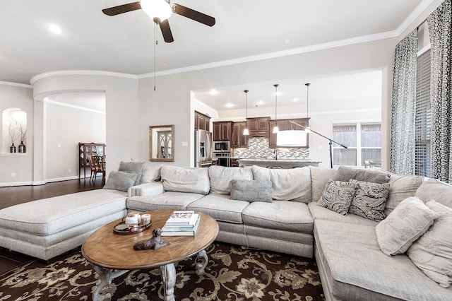 living room featuring ceiling fan, crown molding, and dark wood-type flooring