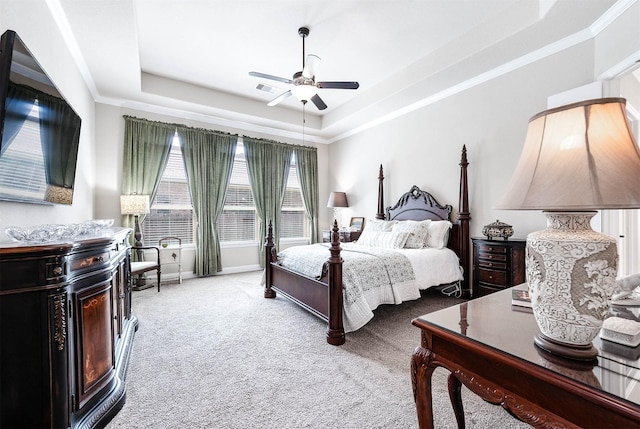 carpeted bedroom with a raised ceiling, ceiling fan, and ornamental molding