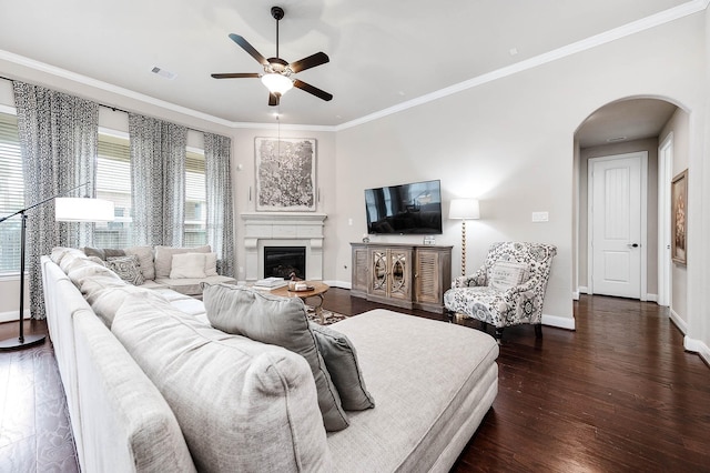 living room featuring dark hardwood / wood-style floors, ceiling fan, and ornamental molding