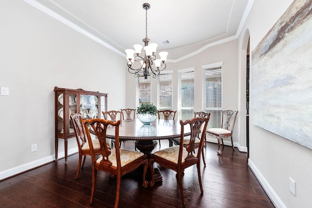 dining area featuring dark hardwood / wood-style floors, crown molding, and a notable chandelier