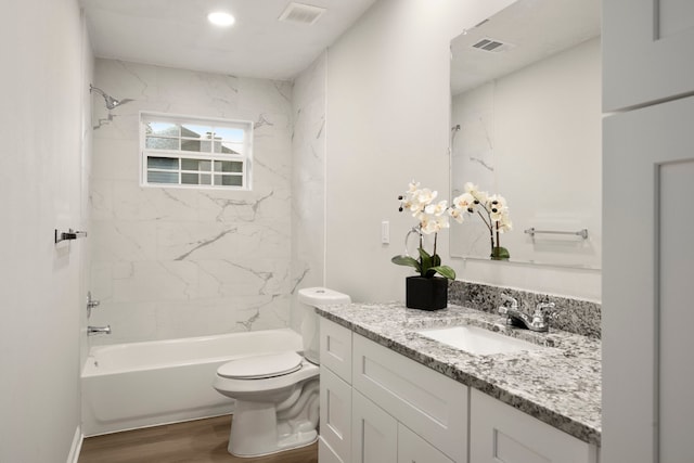 full bathroom with vanity, hardwood / wood-style flooring, toilet, and tiled shower / bath