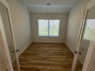 spare room with dark hardwood / wood-style floors and vaulted ceiling