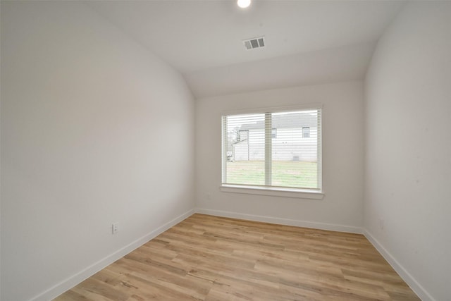 empty room featuring lofted ceiling and light hardwood / wood-style flooring