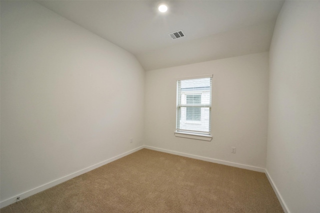 carpeted spare room with lofted ceiling