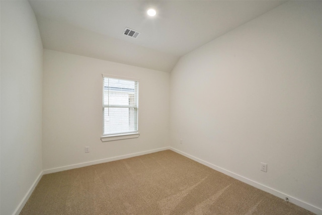 unfurnished room featuring carpet flooring and vaulted ceiling