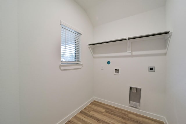 clothes washing area with hookup for a washing machine, hookup for an electric dryer, light wood-type flooring, and hookup for a gas dryer