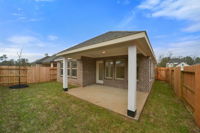 back of house with a patio area and a lawn