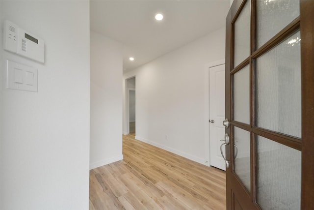 hallway with light hardwood / wood-style floors