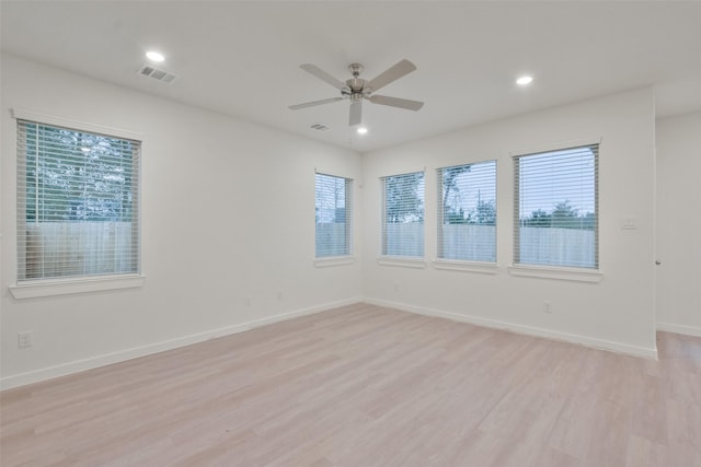 empty room with ceiling fan and light hardwood / wood-style flooring