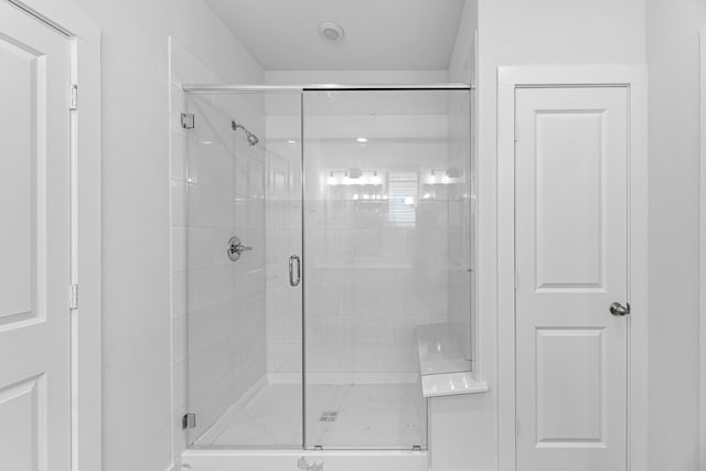 bathroom with a shower with door