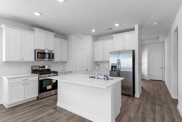 kitchen with appliances with stainless steel finishes, an island with sink, white cabinetry, and sink