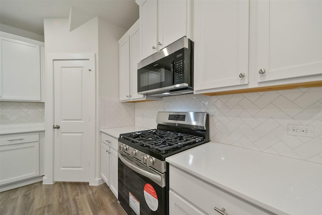 kitchen featuring white cabinetry, stainless steel appliances, decorative backsplash, and hardwood / wood-style flooring