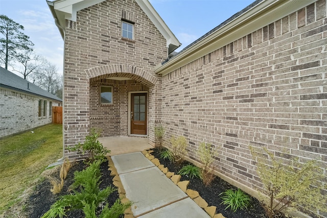 view of exterior entry featuring a lawn