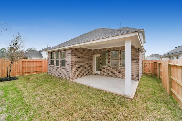 rear view of property featuring a lawn and a patio