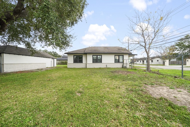 rear view of house featuring a yard