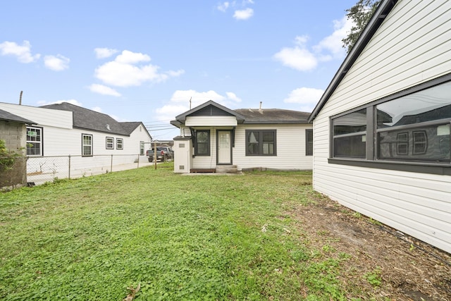 rear view of property with a yard