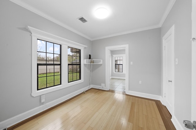 spare room featuring light hardwood / wood-style floors and crown molding