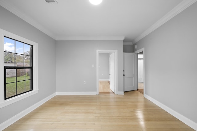 empty room with light wood-type flooring and ornamental molding