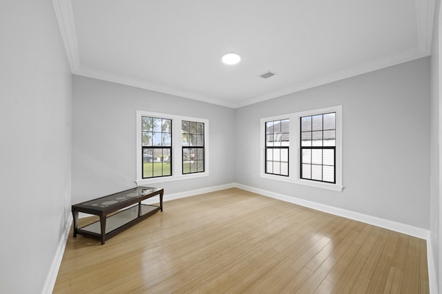 empty room featuring light hardwood / wood-style floors and ornamental molding