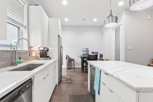 kitchen with white cabinetry, sink, decorative light fixtures, decorative backsplash, and appliances with stainless steel finishes