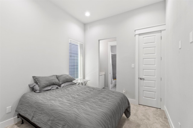 bedroom featuring light carpet and connected bathroom