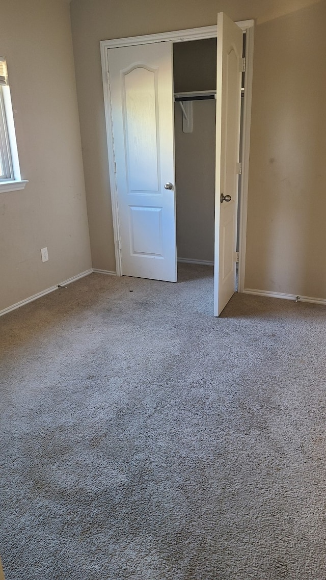 unfurnished bedroom featuring carpet and a closet