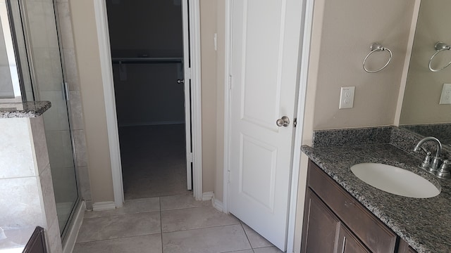 bathroom featuring tile patterned floors, vanity, and a shower with door