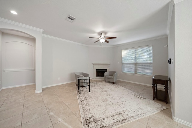 unfurnished room featuring ceiling fan, crown molding, and light tile patterned flooring