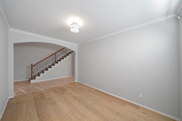 empty room with light wood-type flooring and ornamental molding