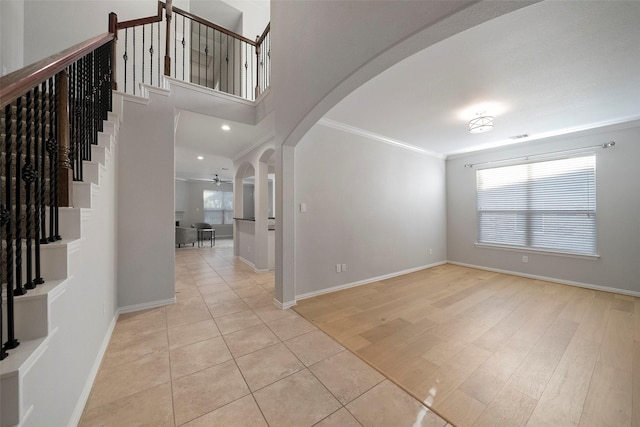 foyer entrance featuring light tile patterned floors, ceiling fan, and ornamental molding