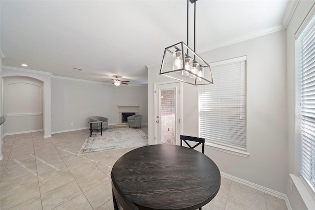 dining area featuring crown molding, light tile patterned floors, and ceiling fan with notable chandelier